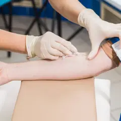 Pielęgniarka w rękawiczkach pobiera krew do badań profilaktycznych.