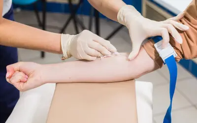 Pielęgniarka w rękawiczkach pobiera krew do badań profilaktycznych.