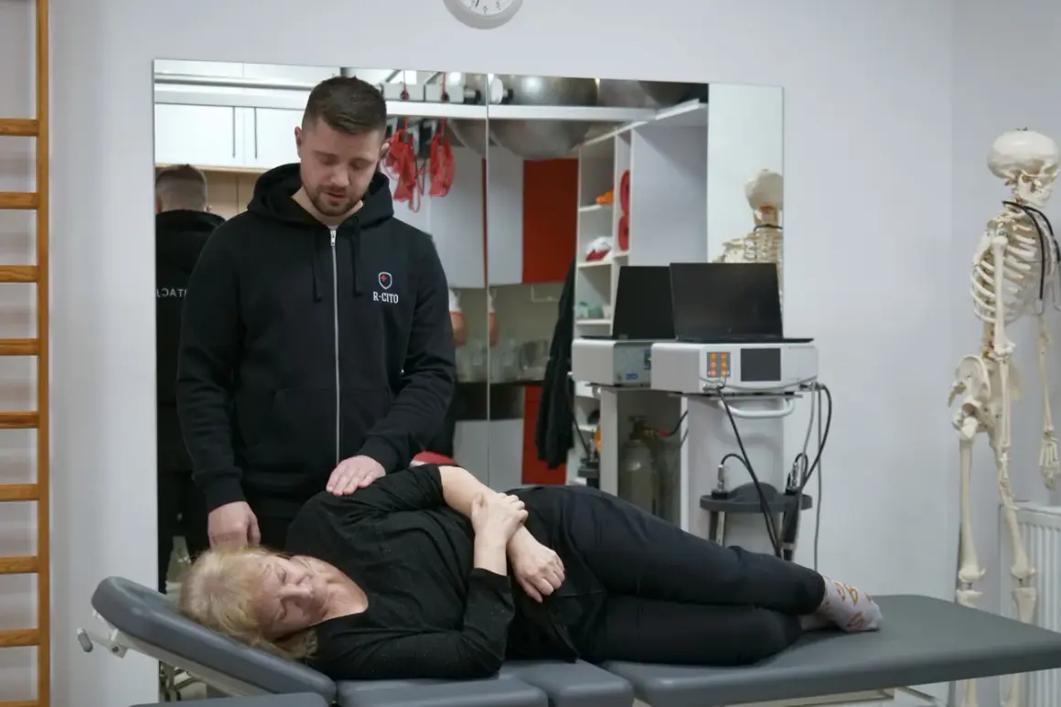 Fizjoterapeuta pomaga pacjentce z bólem kręgosłupa, wykonując delikatny masaż.