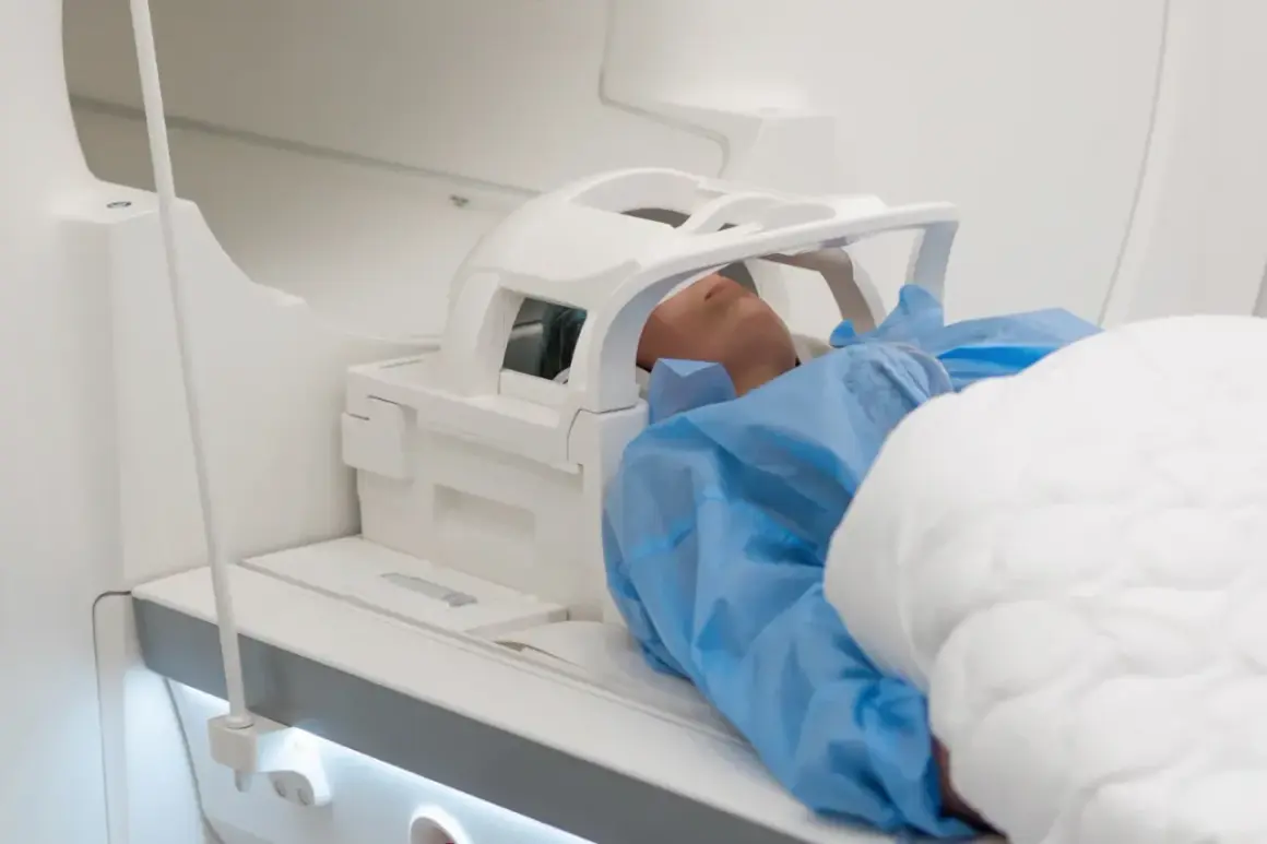 Pacjent leży w aparacie do rezonansu magnetycznego. Czas badania, czyli ile trwa rezonans głowy, zależy od wielu czynników.