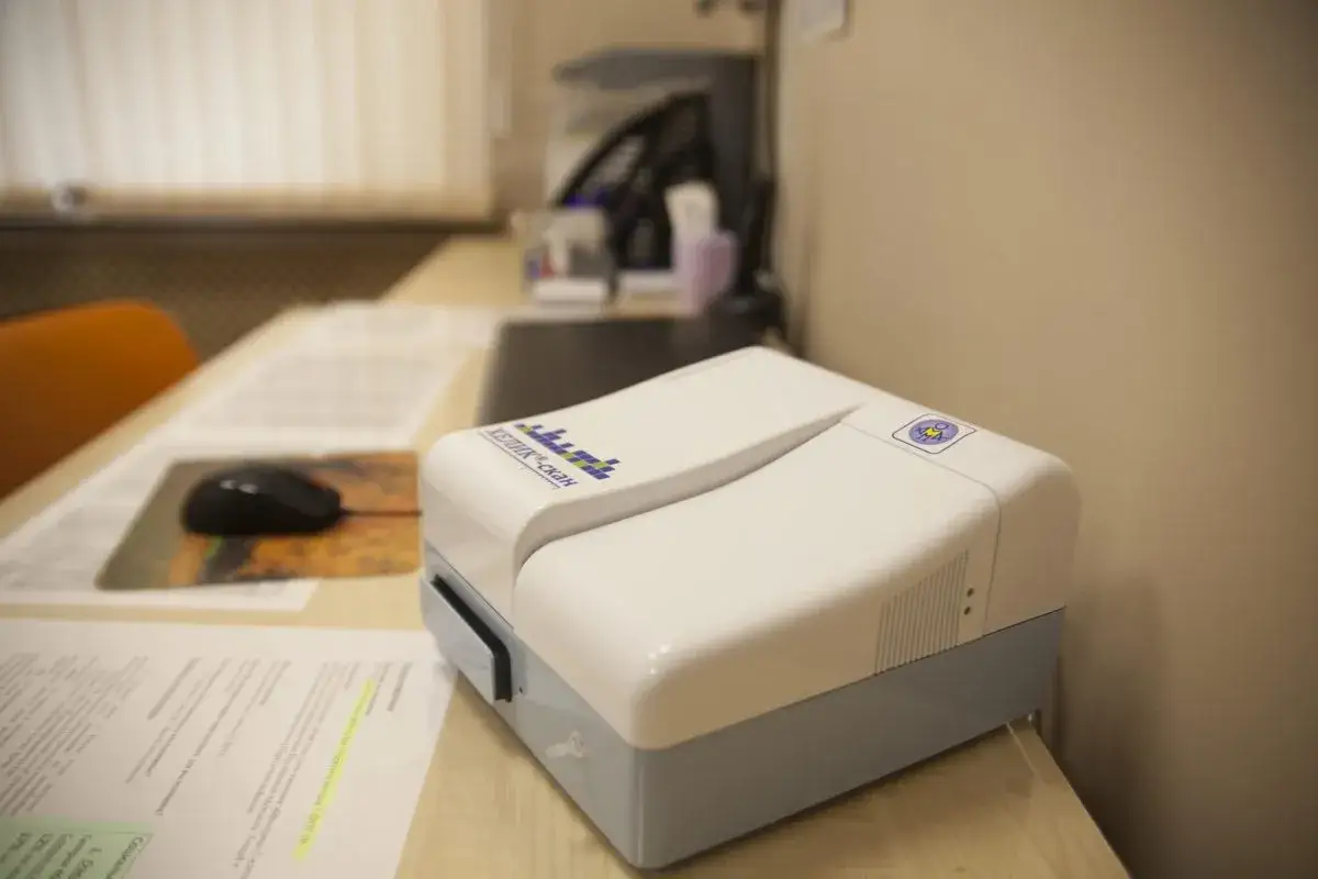 Urządzenie do testu oddechowego Helicobacter. Na biurku obok dokumentów i myszki komputerowej.